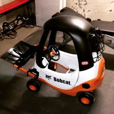 an orange and white toy car sitting on the floor