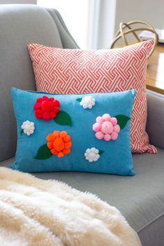 a pillow with flowers on it sitting on a couch