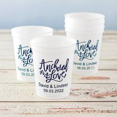 three plastic cups sitting on top of a wooden table