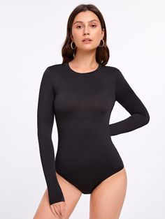 a woman wearing a black bodysuit with long sleeves