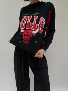 Our absolute favorite Chicago Bulls sweatshirt! Features the classic Chicago Bulls red coloring in the ribbed neckline and inner sleeves. The middle front of the sweatshirt showcases a beautiful print with the Chicago Bulls Logo. The perfect piece to pair with the AGOLDE 90's Pinch Waist Jean. 50% polyester 50% cotton Tag reads Official Licensed Product NBA - Made in USA Recommended for size xs-s, depending on the desired fit. Modeled on a small frame. Please refer to the measurements listed bel Red Sporty Sweatshirt For Loungewear, Sporty Red Sweatshirt For Loungewear, Red Sweatshirt With Ribbed Cuffs For Loungewear, Graphic Print Long Sleeve College Sweater, Long Sleeve Graphic Print Loungewear Sweater, Graphic Print Long Sleeve Loungewear Sweater, Graphic Print Long Sleeve Sweater For Loungewear, Varsity Crew Neck Top With Ribbed Collar, Graphic Print Crew Neck Sweater For Loungewear