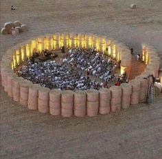 an aerial view of people standing in the middle of a circular structure with lights on it