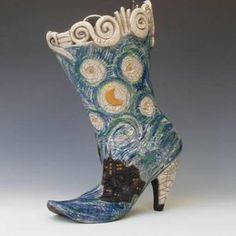 a blue and white boot with an artistic design on the side, in front of a gray background