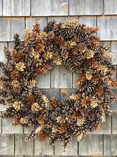 a wreath made out of pine cones on top of a wooden wall