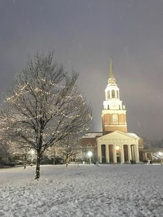 a large building with a clock tower in the middle of it's snowing field