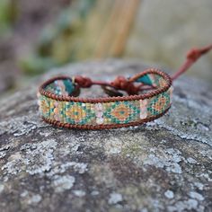 Native American inspired leather wrap bracelet This wrap bracelet is handmade with - Glass beads - Sunstone gemstone beads - Natural brown genuine leather cord - Brown silk cord - Brass button Adjustable with 4 loops to fit the gold metal button. 9in long and .5in wide. Silk Cord, Brown Silk, Western Leather, Leather Wrap Bracelet, Natural Brown, Leather Wraps, Natural Beads, Metal Buttons, Gold Beads