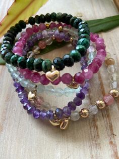 "Beautiful Handmade raw Emerald 7mm, Amethyst 6mm, Tourmaline 6mm, cherry Quartz 5mm, Fluorite 6mm beaded stretchy bracelet.  All come with a gold heart. Bracelet size range from 6.5 to 7 in\", beads vary in size from 5mm, 6mm and 8mm bead size. Please message seller for specifications. Please allow time for workmanship and mail delivery.  Due to the nature and handmade item no piece will be the same. Please message seller if want multiples. Prefect Gifts for loved ones, Gifts for Her, Gifts for Handmade Bracelets Tutorial, Birthday Gemstones, Gold Heart Bracelet, Crystal Bead Jewelry, Stretchy Beaded Bracelet, Raw Emerald, Cherry Quartz, Single Bead, For Her Gifts