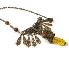 This is a beautiful 1940s vintage Art Nouveau, Victorian Revival style necklace. It features a bronze filigree butterfly with spread wings, twelve filigree dangling drops, and a center pendant drop of ornate bronze metal and citrine yellow faceted glass beads. The chain is stamped metal links and hollow-form filigree round metal beads, and it closes with a spring ring clasp. The necklace is in very good vintage condition, no flaws noted. It is unsigned. The butterfly is 2.5 inches wide and the c Antique Gold Vintage Necklace For Events, Vintage Brass Necklace For Vintage Events, Vintage Brass Necklaces For Vintage Events, Antique Gold Necklace For Vintage Events, Antique Necklaces With Intricate Design For Party, Vintage Antique Gold Necklace With Intricate Design, Antique Gold Vintage Necklace With Intricate Design, Antique Gold Necklace With Intricate Design In Vintage Style, Vintage Bronze Filigree Necklaces