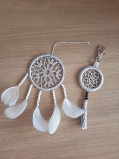 two white dream catchers sitting on top of a wooden table