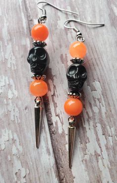 FREE DOMESTIC SHIPPING ONLY Please read the shipping, policies, and procedures Handmade with lots of love! Spooky cool black skull earrings accompanied by neon orange glass rounds, designer silver spaces, and silver dangling spike. The earrings dangle at 3 inches (1cm in width), very light weight. The black skulls have intricate detailing and the earrings are created with silver tone plated precious metals. These earrings make a great fashion statement, especially for Halloween. The earrings are Edgy Handmade Halloween Earrings, Edgy Pierced Halloween Earrings, Edgy Handmade Earrings For Halloween, Edgy Halloween Pierced Earrings, Edgy Pierced Earrings For Halloween, Gothic Skull Earrings For Halloween, Nickel-free Punk Halloween Earrings, Nickel-free Punk Earrings For Halloween, Punk Nickel-free Earrings For Halloween