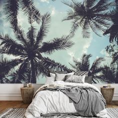 a bed sitting under a palm tree wall mural