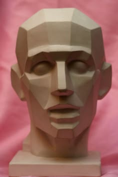 a paper sculpture of a man's face on a pink background