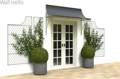 two potted plants sitting next to each other near a white door with black awnings