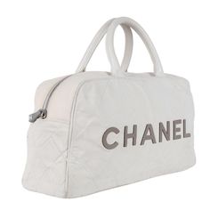 Authentic Chanel bowler bag with a white canvas and gray leather lettering. Features white and gray canvas, leather handles, leather lined interior with zipper pockets, rear zipper pocket, and silver hardware with gray CC zipper pull. Hologram reads: 6648338 Made in 2000-2002 Made in Italy Strap drop: 5" White Designer Satchel With Large Capacity, White Travel Bags With Handles, Designer Canvas Bag With Detachable Handle For Travel, Designer White Coated Canvas Shoulder Bag, White Satchel Canvas Bag For Errands, Designer White Canvas Bag, Luxury White Canvas Bag With Top Carry Handle, Designer Travel Canvas Bag With Dust Bag, White Canvas Travel Bag With Handles