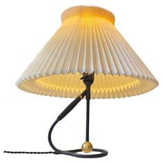 a lamp that is sitting on top of a white surface with a black cord attached to it