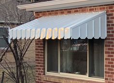 a white awning on the side of a brick building