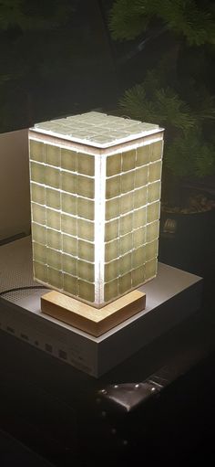 a lamp that is sitting on top of a table in front of some plants and trees