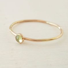 A lovely peridot gemstone has been encased in 14k gold filled and set on a 14k gold filled stacking ring. Band measures 1mm thick. Stone measures 3mm. Ring is available in all sizes. Green Stackable Rings For Everyday, Stackable Yellow Gold Peridot Jewelry, Dainty Green 14k Gold Stackable Rings, Gold Peridot Birthstone Ring, Everyday Green 14k Gold Stackable Rings, Yellow Gold Peridot Stackable Rings, Gold Stackable Rings For Everyday - May Birthstone, Minimalist Gold Peridot Jewelry, Dainty Gold May Birthstone Ring