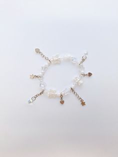 ・❥・White Themed Bracelet, adorned with dangling silver toned and teardrop charms.        ・❥・Opaque and acrylic hearts, star, butterfly and pearl beads make up the bracelet.  ・❥・Bracelet length is about 7.5 inches.  ・❥・Can be adjusted, just make sure to contact me!  ・❥・Perfect as a gift or for any occasion! White Charm Bracelet With Star Charm As Gift, Whimsical White Jewelry With Pearl Charm, Whimsical White Handmade Charm Bracelet, Whimsical Handmade White Charm Bracelet, White Dainty Metal Charm Bracelet, Dainty White Metal Charm Bracelet, Dainty White Charm Bracelet With Pearl, Adjustable White Charm Bracelet With Star Charm, Dainty White Dangle Bracelets