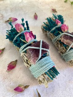 two pieces of rope with flowers on them sitting on top of a white cloth covered ground