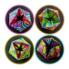 four different colored origami pieces sitting on top of each other in circular frames