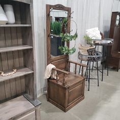 a room filled with lots of furniture next to a wall mounted mirror and wooden shelves