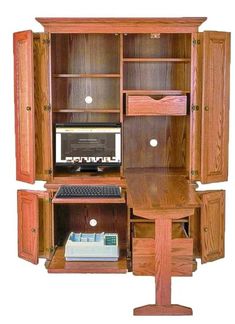 a computer desk with a monitor and keyboard on it's side, sitting in front of a wooden cabinet