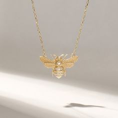 Embrace the beauty of nature and add a touch of whimsical elegance to your daily attire with our Pave Diamond Realistic Bee Necklace. Crafted in genuine 14k solid yellow gold, this necklace showcases the intricate and lifelike details of a 3D honey bee. The bee pendant sparkles with pave diamonds, creating a stunning contrast to the rich gold, making it a statement piece that catches the eye. Whether you wear it as a daily necklace or for special occasions, it adds a touch of sophistication and charm to your style, making it a perfect gift for nature enthusiasts, bee lovers, or anyone who appreciates unique and symbolic jewelry. Features * Made to Order. * Gold KT: 14KT * Custom Gold Color: Yellow Gold * Charm 12.80mm x 20.10mm * Charm Thickness: 1.25 mm * Diamond Color-Clarity: D-E-F colo Gold Bee Necklace, Gold Bee, Bee Pendant, Symbolic Jewelry, Bee Necklace, Gold Charm, Pave Diamonds, Luxury Jewelry, Colored Diamonds