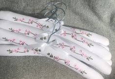 several white gloves with pink flowers on them