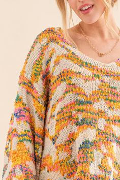 a woman wearing a multicolored knit sweater