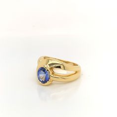 This custom sapphire ring is created in 18K yellow gold. There is a half bezel set royal blue  Ceylon sapphire featured in the ring, weighing 1.58 carat. The stone was weighed loose. The ring itself has a flowing bypass design with a split shank, weighing a total of 12.3 grams. Yellow Gold Tanzanite Ring With Polished Finish, Modern Yellow Gold Sapphire Ring With Center Stone, Yellow Gold Tanzanite Rings, Timeless Sapphire Ring With Bezel Setting, Modern Gold Sapphire Ring With Center Stone, Gold Tanzanite Round Rings, Classic Yellow Gold Ring With Lab-created Sapphire, Gold Tanzanite Birthstone Ring, Gold Birthstone Ring With Tanzanite