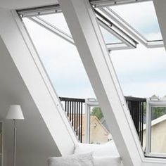 a white couch sitting under three windows in a room