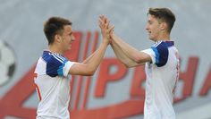 two soccer players giving each other high fives