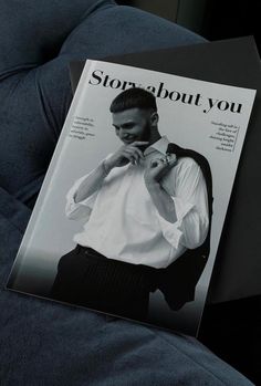 a magazine with a man wearing a white shirt and black pants sitting on a couch