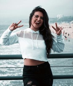 a woman posing for the camera with her hands in the air