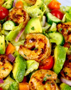 a salad with shrimp, avocado and tomatoes