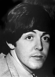 a black and white photo of a man in a suit with his eyes wide open