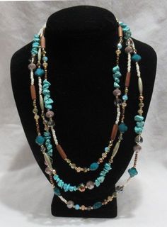 a necklace with beads and stones on a mannequin