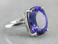 "One of the very finest gemstones currently in our collection, this Tanzanite is collectors quality, filled with color and shine. Weighing in at over ten carats, this incredible stone features a deep, true indigo color filled with flashed of cobalt and cornflower. We've set this tanzanite in a simple, substantial platinum mounting, one versatile enough to wear day or evening. Metal: Platinum Gem: Tanzanite, 10.20 Carats Gem Measures: 11 x14 mm, Oval Size: 5.25 Marks: \"PT950 J.L.J\" Stamped on t Luxury Tanzanite Gemstones For Gift, Luxury Tanzanite Gemstones As A Gift, Brilliant Cut Tanzanite Gemstones For Gift, Brilliant Cut Tanzanite Gemstones As Gift, Modern Topaz Ring With Gemstone Accents For Formal Occasions, Luxury Round Ruby Ring, Modern Amethyst Ring With Accent Stones For Formal Events, Modern Amethyst Ring With Accent Stones For Formal Occasions, Luxury Sapphire Gemstones With Gemstone Accents