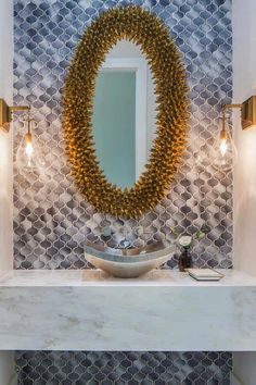 a bathroom with a sink, mirror and lights on the counter top in front of it