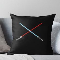 two lightsabes are crossed on black background with red and blue colors throw pillow