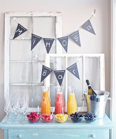 a table topped with drinks and fruit next to a window