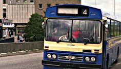 a blue and yellow bus driving down the street