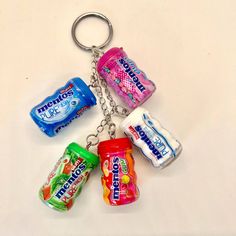 four different flavors of chewing gum on a keychain that is hanging from a chain