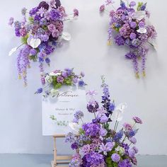 purple and white flowers are arranged on the wall