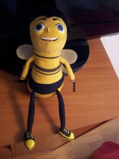 a stuffed bee sitting on top of a wooden table