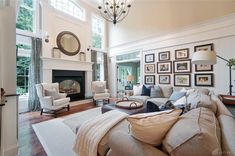 a living room filled with lots of furniture and pictures on the wall above the fireplace