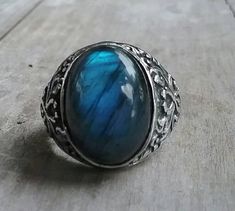 solid large labradorite ring mans wedding or dress ring beautiful scroll antique effect. solid sterling silver (925) Solid not hollowed out in the back stone flashes blues and grey with black flecks..few inclusions. Avaliable in many stones Stone measures 17 mm x13mm (6/8 ''x 4/8'' approx.) The stone will be set once sold.1 This ring I can make any size. It weights 12.2 gms approx It is 21mm (7/8 '' wide) It tapers to 3.5mmat the back If a different size is required pls convo me Spiritual Adjustable Jewelry With Round Stone, Handmade Adjustable Antique Silver Jewelry, Heirloom Sterling Silver Cabochon Jewelry, Heirloom Sterling Silver Open Ring, Elegant Metal Rings With Stone Setting, Elegant Metal Rings With Gemstones, Elegant Moonstone Round Stone Jewelry, Heirloom Sterling Silver Promise Ring Jewelry, Unique Oval Cabochon Jewelry