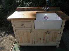 a kitchen sink sitting under a faucet next to a wooden counter and cabinet