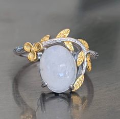 Fast free shipping Gemstone has been tested on one of the most accurate and reliable gemstone testing machines. Moonstone is genuine and is naturally mined. The flashy moonstone square earrings are brilliant. A cute moonstone sterling silver ring with 14k yellow gold overlay is perfect for the spring. It will remind you of white cherry blossoms in the spring. This moonstone ring has iridescent beautiful blue flashing hues. Rainbow Moonstone activates the Crown Chakra bringing In loving white hea Luxury Untreated Moonstone Ring For Anniversary, Luxury Fine Jewelry Moonstone Ring For Anniversary, White Cabochon Moonstone Ring Fine Jewelry, Fine Jewelry White Cabochon Moonstone Ring, White Cabochon Moonstone Ring In Fine Jewelry Style, White Oval Cabochon Moonstone Ring, Elegant White Moonstone Ring, Oval Cabochon, Elegant White Moonstone Ring With Oval Cabochon, Elegant White Oval Cabochon Moonstone Ring